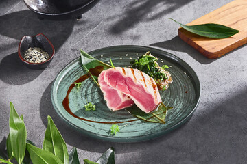 Grilled tuna steak with sauteed spinach, bright natural lighting, overhead composition