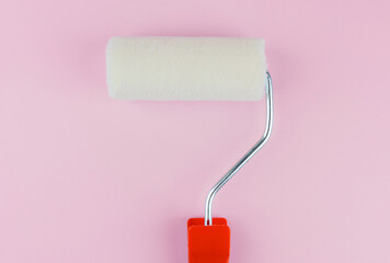 Single red handled roller on pink background for simplicity and home painting concept
