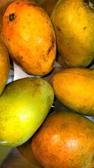 Closeup of Ripe Yellow and Green Mangos on Metal Surface, Fresh Fruit Display