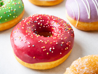 Donuts with different colorful icing designs on a white background.