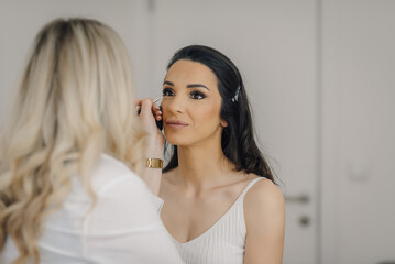 Professional makeup artist applying makeup to a client's eye