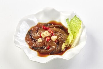 Marinated shrimp in soy sauce garnished with garlic, chili, and sesame seeds, served with fresh lettuce on white plate. savory and appetizing seafood dish