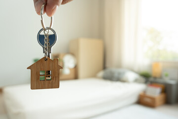 Moving house, relocation. Man hold key house keychain in new apartment, inside the room was a...