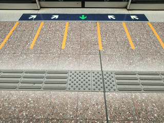 A photo of a subway train entrance markings on the floor.