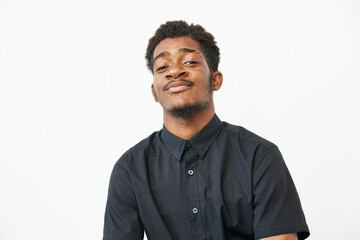 Confident black man with a charming smile against a light backdrop, showcasing his style and...