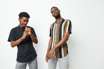 Two young African American men dressed in stylish outfits, showcasing confidence and charisma against a minimalist background. Perfect for lifestyle and fashion themes.