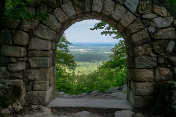 Obraz premium a stone arch with a view of a valley