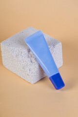 Purple packaging for cream, sunscreen or serum on with stylish props on cream background.