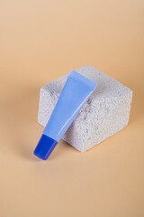 Purple packaging for cream, sunscreen or serum on with stylish props on cream background.