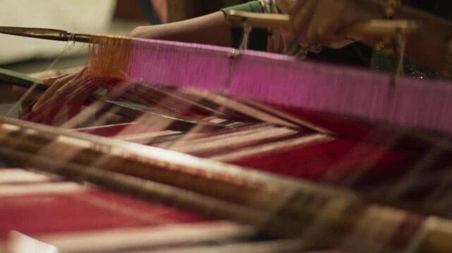 Close-Up of Hands Weaving Silk Fabric Using a Traditional Wooden Loom &ndash; Indonesian Textile Craftsmanship