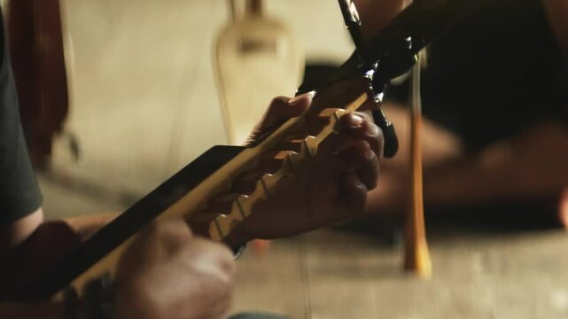 Close-Up of Hands Playing the Traditional Bugis Kecapi &ndash; Indonesian Cultural String Instrument Performance