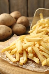 Tasty french fries on wooden table, closeup