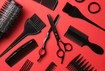 Fototapeta premium Different hairdresser's tools on red background, flat lay