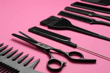 Different hairdresser's tools on pink background, closeup