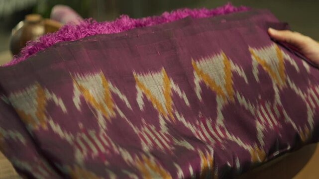 Close-Up of a Person Holding and Examining a Silk Sarong &ndash; Traditional Fabric and Textile Appreciation