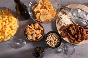 Beer and snacks on grey table, flat lay