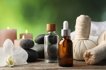 Composition with cosmetic products, spa stones and herbal bags on wooden table, closeup