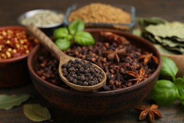 Different aromatic spices on wooden table, closeup