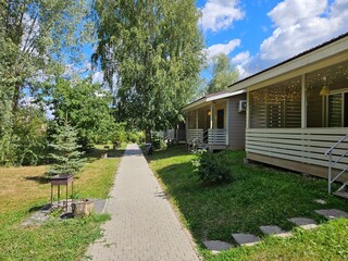 House with a porch and a walkway leading to it. The walkway is made of bricks in country village dacha