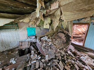 Room with a pile of bricks and a green chair. The chair is on the floor. The room is in a state of...