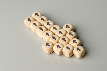 A large arrow formed by multiple wooden blocks with black arrows pointing in the opposite...