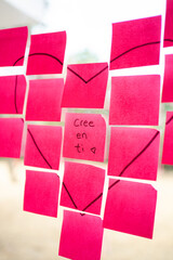 Believe in yourself: pink sticky notes forming heart shape with motivational message in spanish