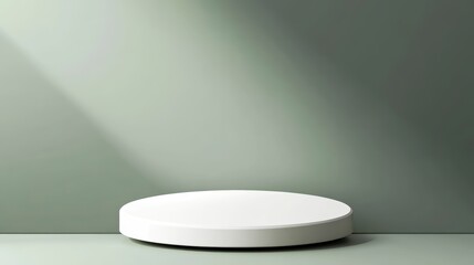 Minimalist white round podium against a sage green wall with dramatic lighting.