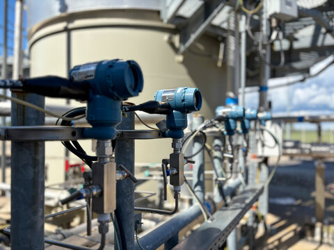 A close-up photo of multiple pressure transmitters installed in an industrial facility.