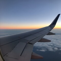 Obraz premium Sunset Flight: Wing View from an Airplane over Clouds , Airplane Wing Silhouetted Against a Vibrant Sky during Sunset