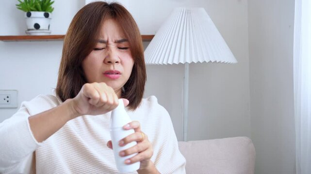 Asian woman taking antacid gel to relieve heartburn, stomach pain, gas, and discomfort, showing a common way to treat GERD, gastritis, and other digestive problems
