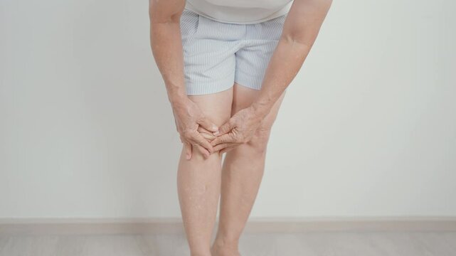 Elderly woman having knee ache and muscle pain due to Runners Knee or Patellofemoral Pain Syndrome, osteoarthritis, arthritis, rheumatism and Patellar Tendinitis. Senior health and medical concept