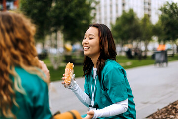 Nurses enjoy a meal in the park while helping at a community event during the sunny afternoon