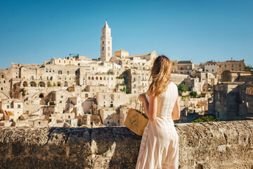 Woman tourist enjoying panoraming view of Matera city in Italy.Young woman in romantic dress and...