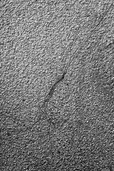 A detailed close-up reveals a rough, granular texture across a weathered surface, bisected by a...