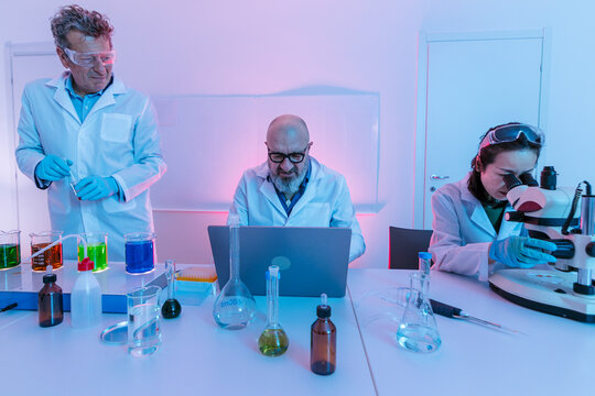 Scientists working in laboratory using microscopes and computers