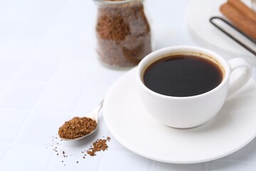 Cup of aromatic coffee and granulated instant coffee on white table, closeup. Space for text