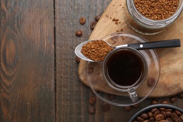 Aromatic hot drink, instant coffee and beans on wooden table, flat lay. Space for text