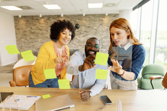 Diverse team collaborating and planning in a modern office with sticky notes