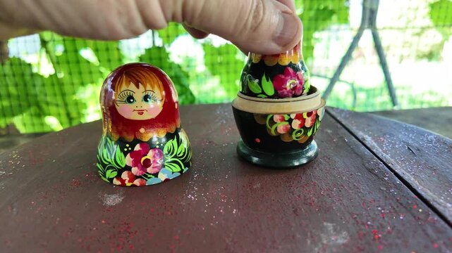 wooden matryoshka doll. Hand Holding a Wooden Matryoshka Doll &ndash; Traditional Russian Nesting Doll. Collection of traditional Russian nesting dolls. Beautiful handmade matryoshka dolls in a row.