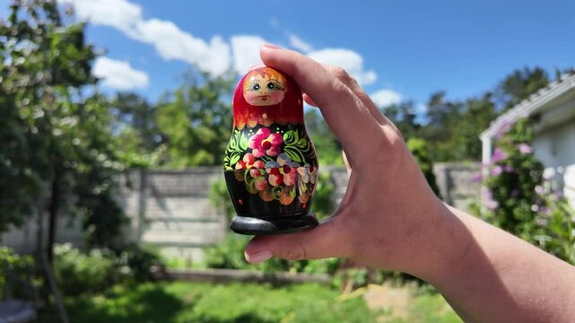 wooden matryoshka doll. Hand Holding a Wooden Matryoshka Doll &ndash; Traditional Russian Nesting Doll. Collection of traditional Russian nesting dolls. Beautiful handmade matryoshka dolls in a row.
