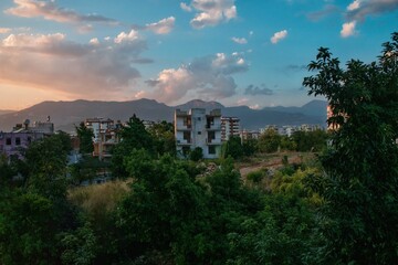 Cloudy sky over old village houses in Turkey with tree leaves in the foreground