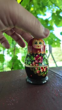 wooden matryoshka doll. Hand Holding a Wooden Matryoshka Doll &ndash; Traditional Russian Nesting Doll. Collection of traditional Russian nesting dolls. Beautiful handmade matryoshka dolls in a row.