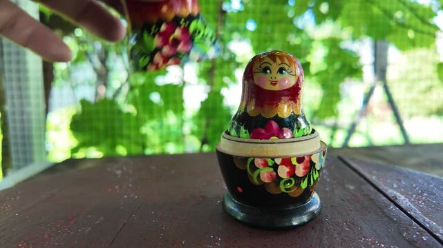 wooden matryoshka doll. Hand Holding a Wooden Matryoshka Doll &ndash; Traditional Russian Nesting Doll. Collection of traditional Russian nesting dolls. Beautiful handmade matryoshka dolls in a row.