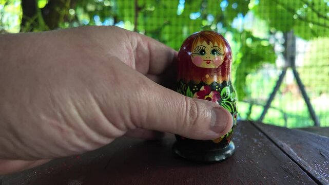 wooden matryoshka doll. Hand Holding a Wooden Matryoshka Doll &ndash; Traditional Russian Nesting Doll. Collection of traditional Russian nesting dolls. Beautiful handmade matryoshka dolls in a row.