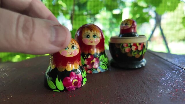 wooden matryoshka doll. Hand Holding a Wooden Matryoshka Doll &ndash; Traditional Russian Nesting Doll. Collection of traditional Russian nesting dolls. Beautiful handmade matryoshka dolls in a row.