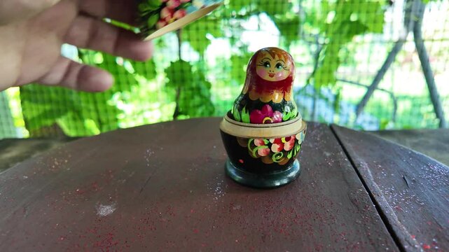 wooden matryoshka doll. Hand Holding a Wooden Matryoshka Doll &ndash; Traditional Russian Nesting Doll. Collection of traditional Russian nesting dolls. Beautiful handmade matryoshka dolls in a row.