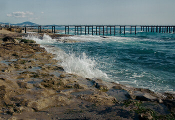 Stormy winter sea with rocky shore and dramatic waves