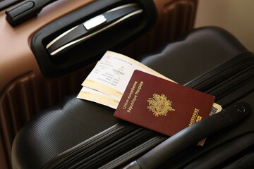 French passport with tickets lies on touristic suitcase close up in airport waiting hall
