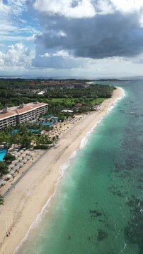 Aerial view of Bali island coastline, tropical beach with hotel at sunny day.Nusa Dua.Indonesia.Vertical video