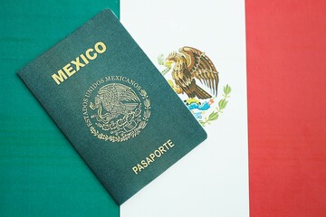 Mexican passport lies on Mexico flag close up. Travel and citizenship